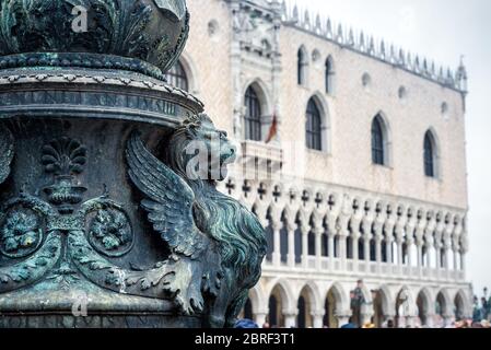 Detail of the architecture of the Saint Mark`s Square in Venice, Italy. Doge`s Palace in the background. The winged lion is a symbol of Venice. Stock Photo